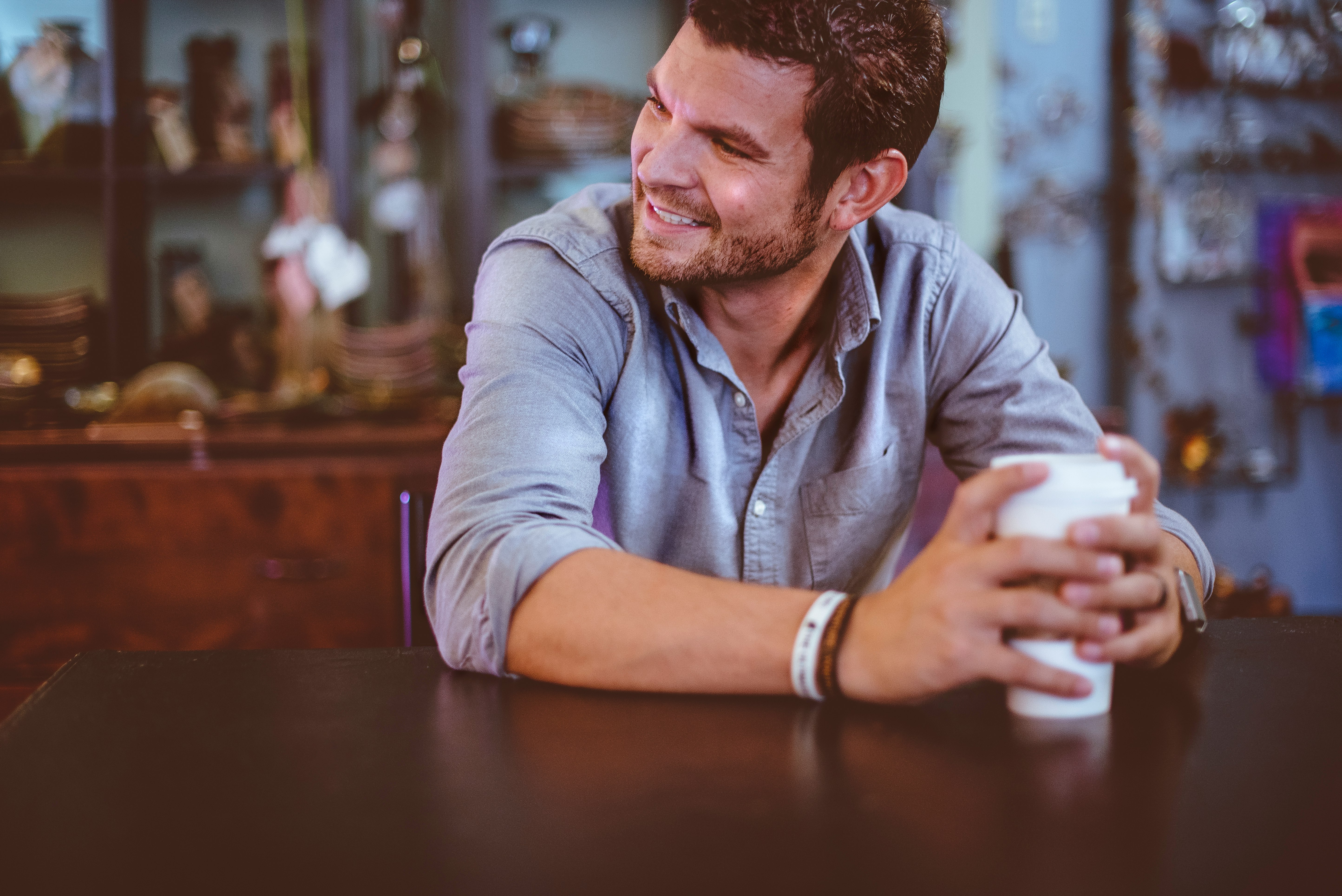 man holding cup on table